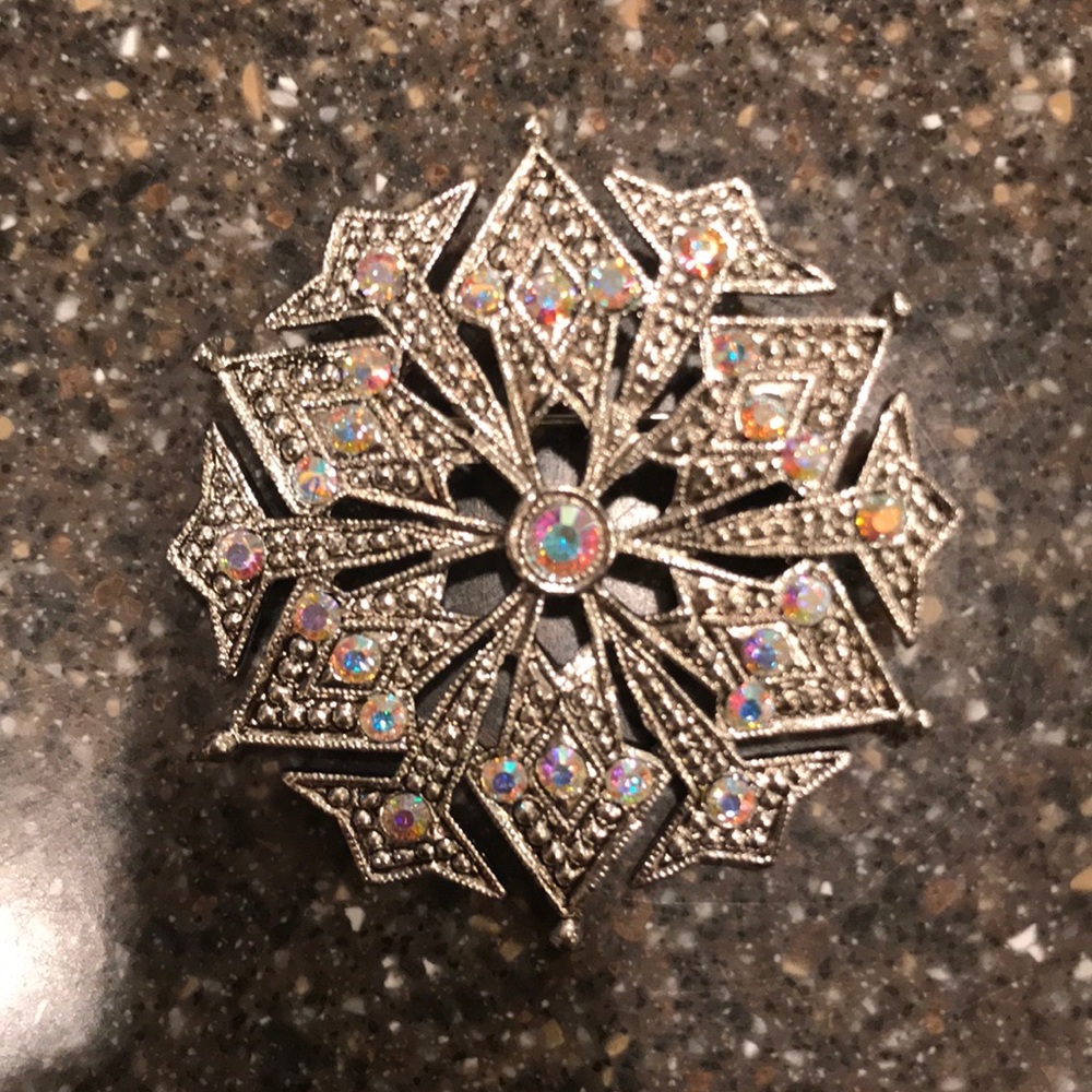 Rhinestone and silver snowflake brooch.
